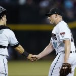 Arizona Diamondbacks pitcher Mark Melancon (34) shakes hands with catcher Daulton Varsho, left, after the final out of the team's baseball game against the Kansas City Royals Tuesday, May 24, 2022, in Phoenix. The Diamondbacks won 8-6. (AP Photo/Ross D. Franklin)