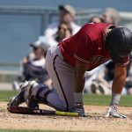 Arizona Diamondbacks' David Peralta goes down after fouling a ball off his foot during the eighth inning of the first baseball game of the team's doubleheader against the Los Angeles Dodgers on Tuesday, May 17, 2022, in Los Angeles. (AP Photo/Marcio Jose Sanchez)