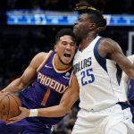 Phoenix Suns guard Devin Booker (1) drives to the basket against Dallas Mavericks forward Reggie Bullock (25) during the first half of Game 3 of an NBA basketball second-round playoff series, Friday, May 6, 2022, in Dallas. (AP Photo/Tony Gutierrez)