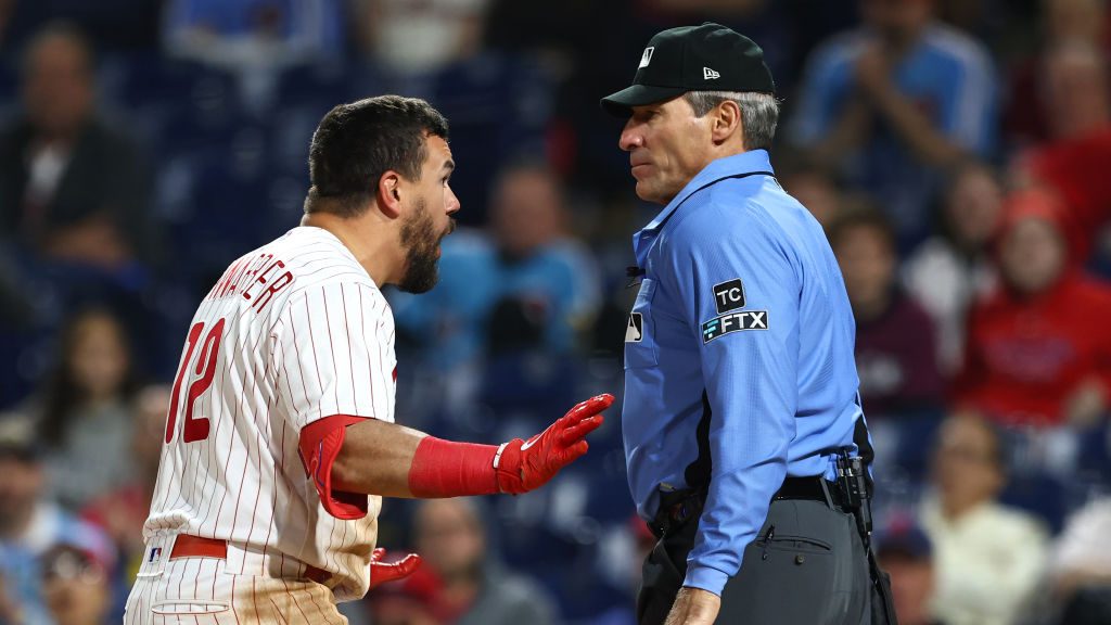 Kyle Schwarber #12 of the Philadelphia Phillies argues with home plate umpire Angel Hernandez after...