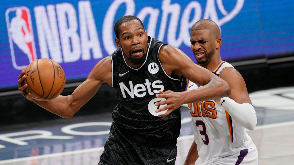 Kevin Durant #7 of the Brooklyn Nets drives to the basket as Chris Paul #3 of the Phoenix Suns defe...