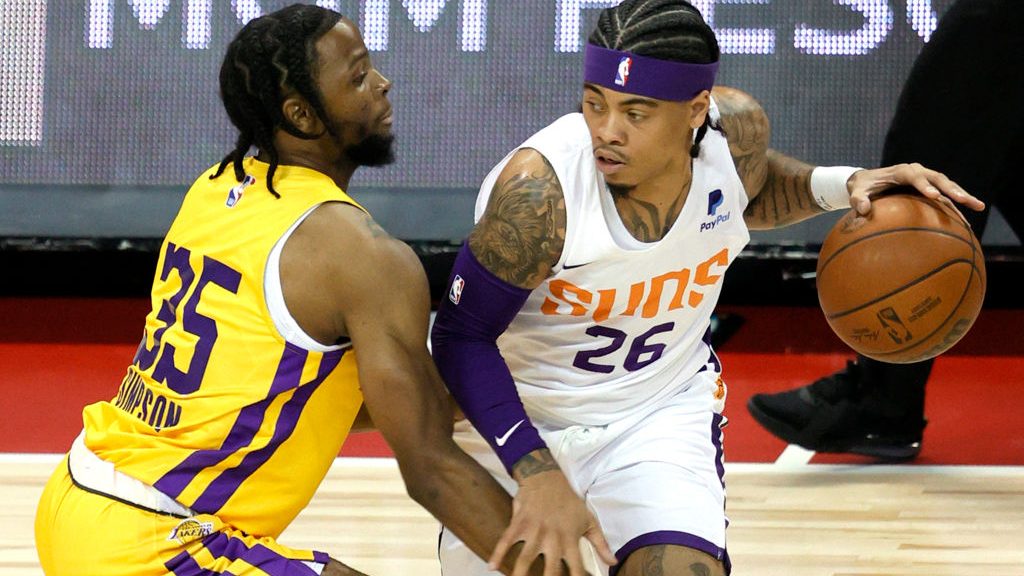 Nate Mason #26 of the Phoenix Suns brings the ball up the court against Zavier Simpson #35 of the L...
