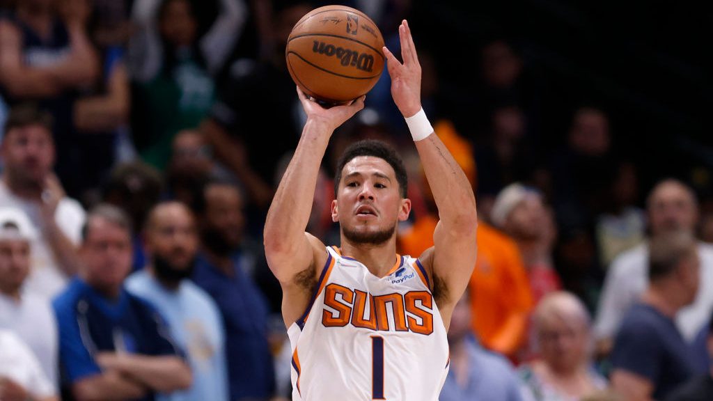 Devin Booker #1 of the Phoenix Suns shoots the ball against Dwight Powell #7 of the Dallas Maverick...