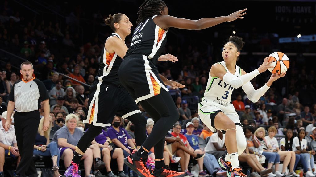 Aerial Powers #3 of the Minnesota Lynx looks to pass under pressure from Diana Taurasi #3 and Tina ...
