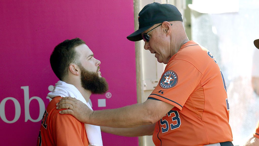 Starting pitcher Dallas Keuchel #60 (L) of the Houston Astros listens to pitching coach Brent Strom...
