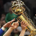 Golden State Warriors guard Stephen Curry, center, holds up the Larry O'Brien Championship Trophy with teammates after defeating the Boston Celtics in Game 6 of basketball's NBA Finals, Thursday, June 16, 2022, in Boston. (AP Photo/Steven Senne)