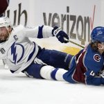 Colorado Avalanche defenseman Bowen Byram (4) and Tampa Bay Lightning center Steven Stamkos (91) fall to the ice during the first period of Game 1 of the NHL hockey Stanley Cup Final on Wednesday, June 15, 2022, in Denver. (AP Photo/John Locher )