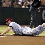 Cincinnati Reds third baseman Mike Moustakas is unable to make a play on a single hit by Arizona Diamondbacks' Carson Kelly during the fourth inning of a baseball game Monday, June 13, 2022, in Phoenix. (AP Photo/Ross D. Franklin)