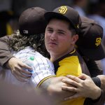 San Diego Padres relief pitcher Adrián Morejón, center, gets hugs from catcher Jorge Alfaro, left, and pitcher Blake Snell before a baseball game against the Arizona Diamondbacks, Wednesday, June 22, 2022, in San Diego. (AP Photo/Gregory Bull)