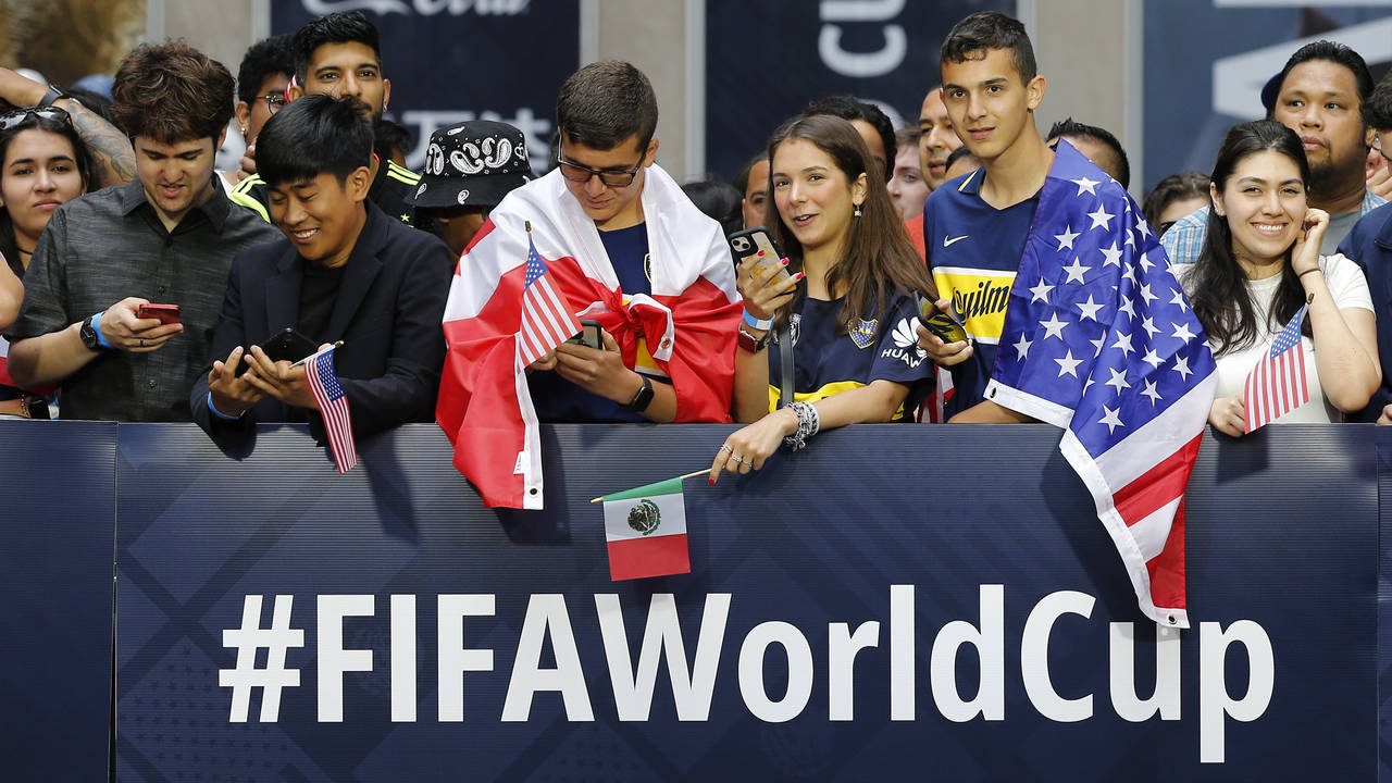 Fans wait along 6th Ave. for FIFA's announcement of the names of the host cities for the 2026 World...