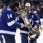 Tampa Bay Lightning center Steven Stamkos (91) shows left wing Pat Maroon (14) the Prince of Wales trophy after the team defeated the New York Rangers during Game 6 of the NHL hockey Stanley Cup playoffs Eastern Conference finals Saturday, June 11, 2022, in Tampa, Fla. The Lightning advanced to the Stanley Cup Finals. (AP Photo/Chris O'Meara)