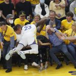 Golden State Warriors forward Draymond Green (23) falls into a row of fans during the first half of Game 5 of basketball's NBA Finals against the Boston Celtics in San Francisco, Monday, June 13, 2022. (AP Photo/John Hefti)