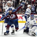 Colorado Avalanche left wing J.T. Compher, left, celebrates next to Tampa Bay Lightning goaltender Andrei Vasilevskiy, right, after an overtime goal by Andre Burakovsky in Game 1 of the NHL hockey Stanley Cup Final on Wednesday, June 15, 2022, in Denver. (AP Photo/John Locher )