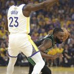 Boston Celtics guard Jaylen Brown, right, is defended by Golden State Warriors forward Draymond Green (23) during the first half of Game 5 of basketball's NBA Finals in San Francisco, Monday, June 13, 2022. (AP Photo/Jed Jacobsohn)