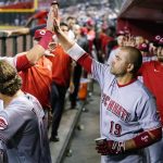 Cincinnati Reds' Matt Reynolds (4) celebrates his run scored against the Arizona Diamondbacks with Reds' Joey Votto (19) as Reds' Kyle Farmer (17) looks on during the sixth inning of a baseball game Monday, June 13, 2022, in Phoenix. (AP Photo/Ross D. Franklin)