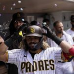 San Diego Padres' Jorge Alfaro is congratulated in the dugout after his home run during the sixth inning of the team's baseball game against the Arizona Diamondbacks, Wednesday, June 22, 2022, in San Diego. (AP Photo/Gregory Bull)