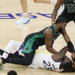 Golden State Warriors forward Draymond Green, bottom, tries to hold onto the ball under Boston Celtics guard Jaylen Brown during the first half of Game 5 of basketball's NBA Finals in San Francisco, Monday, June 13, 2022. (AP Photo/John Hefti)
