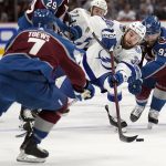 Tampa Bay Lightning left wing Brandon Hagel (38) reaches for the puck between Colorado Avalanche defenseman Devon Toews (7) and left wing Gabriel Landeskog (92) during the first period of Game 1 of the NHL hockey Stanley Cup Final on Wednesday, June 15, 2022, in Denver. (AP Photo/John Locher)
