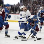 Tampa Bay Lightning center Brayden Point (21) is defended by Colorado Avalanche left wing Artturi Lehkonen (62) during the third period of Game 1 of the NHL hockey Stanley Cup Final on Wednesday, June 15, 2022, in Denver. (AP Photo/John Locher )