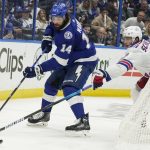 Tampa Bay Lightning left wing Pat Maroon (14) passes the puck by New York Rangers defenseman Braden Schneider (45) during the second period in Game 6 of the NHL hockey Stanley Cup playoffs Eastern Conference finals, Saturday, June 11, 2022, in Tampa, Fla. (AP Photo/Chris O'Meara)