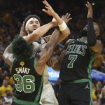 Golden State Warriors guard Klay Thompson, middle, is defended by Boston Celtics guard Marcus Smart (36) and guard Jaylen Brown (7) during the second half of Game 5 of basketball's NBA Finals in San Francisco, Monday, June 13, 2022. (AP Photo/Jed Jacobsohn)