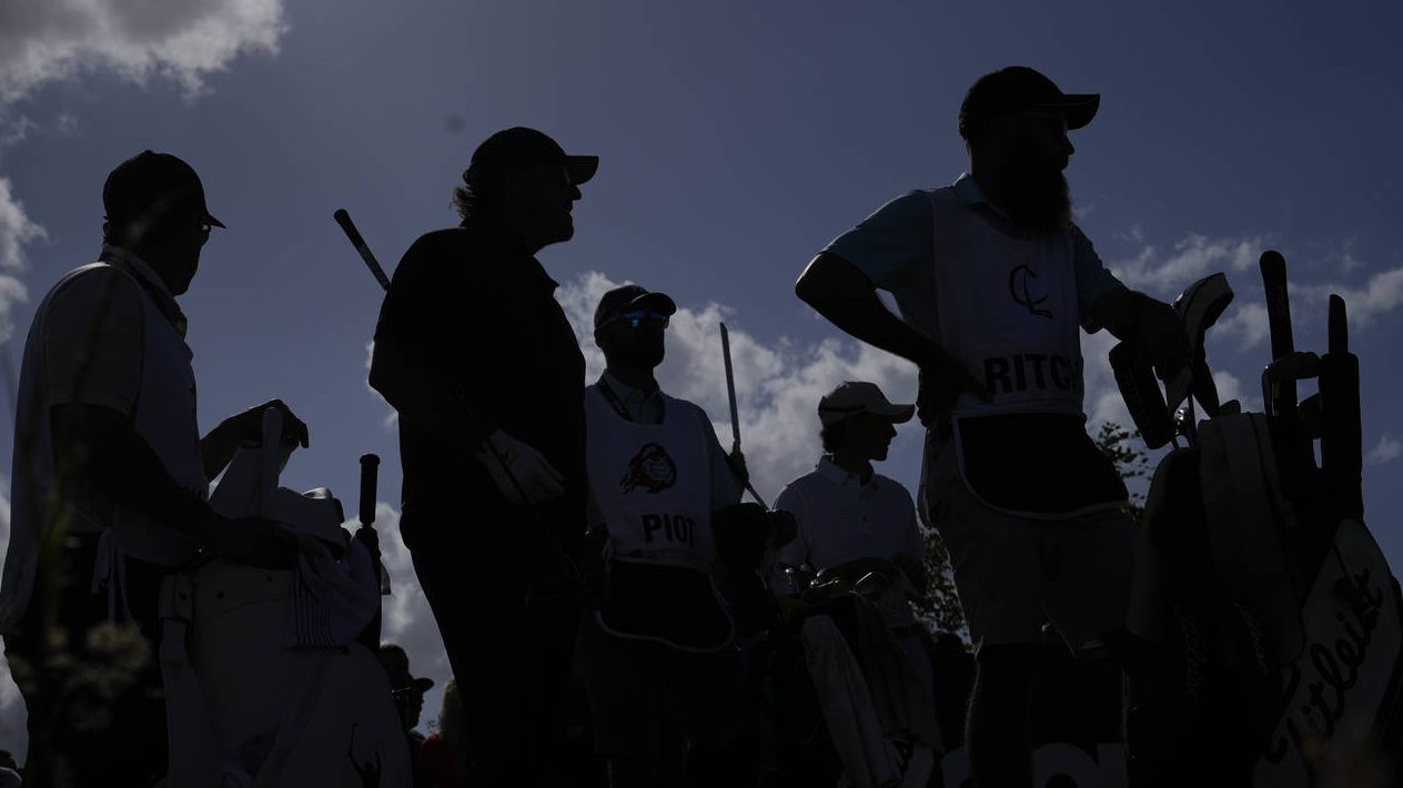 Phil Mickelson of the United States , second left, waits to play his tee shot on the 16th hole duri...