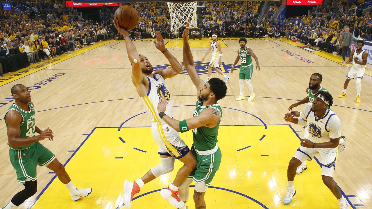 Golden State Warriors guard Stephen Curry, middle left, shoots against Boston Celtics forward Jayso...