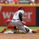 Cincinnati Reds' TJ Friedl, back, steals second base ahead of the tag from Arizona Diamondbacks' Ketel Marte during the second inning of a baseball game in Cincinnati, Thursday, June 9, 2022. (AP Photo/Aaron Doster)