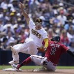 San Diego Padres third baseman Ha-Seong Kim, left, falls over Arizona Diamondbacks' Jordan Luplow (8) after tagging him out on a fielder's choice by Jake Hager during the fourth inning of a baseball game Wednesday, June 22, 2022, in San Diego. Hager was safe at first on the play. (AP Photo/Gregory Bull)
