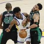Golden State Warriors forward Andrew Wiggins, middle, goes toward the ball between Boston Celtics center Al Horford (42) and forward Jayson Tatum during the second half of Game 5 of basketball's NBA Finals in San Francisco, Monday, June 13, 2022. (AP Photo/John Hefti)