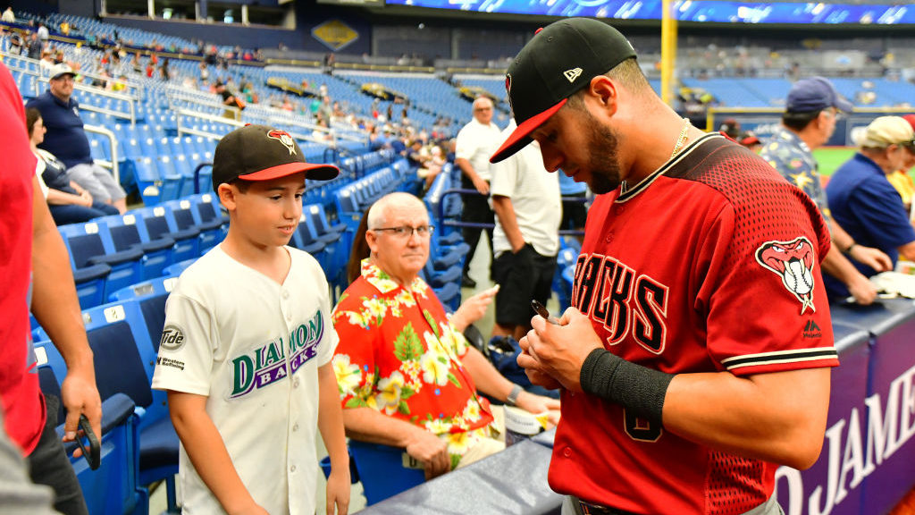 David Peralta #6 of the Arizona Diamondbacks signs an autograph for a young fan before a game again...