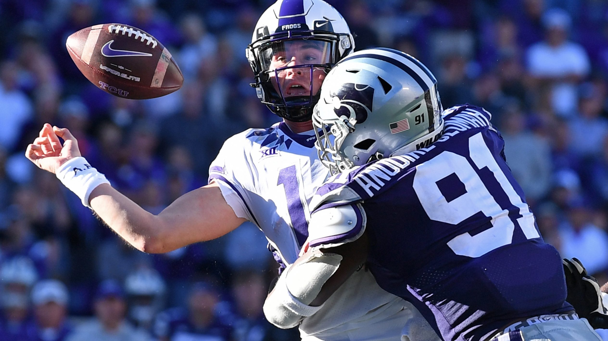Quarterback Chandler Morris #14 of the TCU Horned Frogs fumbles the ball after getting hit by defen...