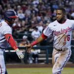 Washington Nationals' Victor Robles (16) is congratulated by Juan Soto after Robles scored against the Arizona Diamondbacks during the third inning of a baseball game Saturday, July 23, 2022, in Phoenix. (AP Photo/Ross D. Franklin)