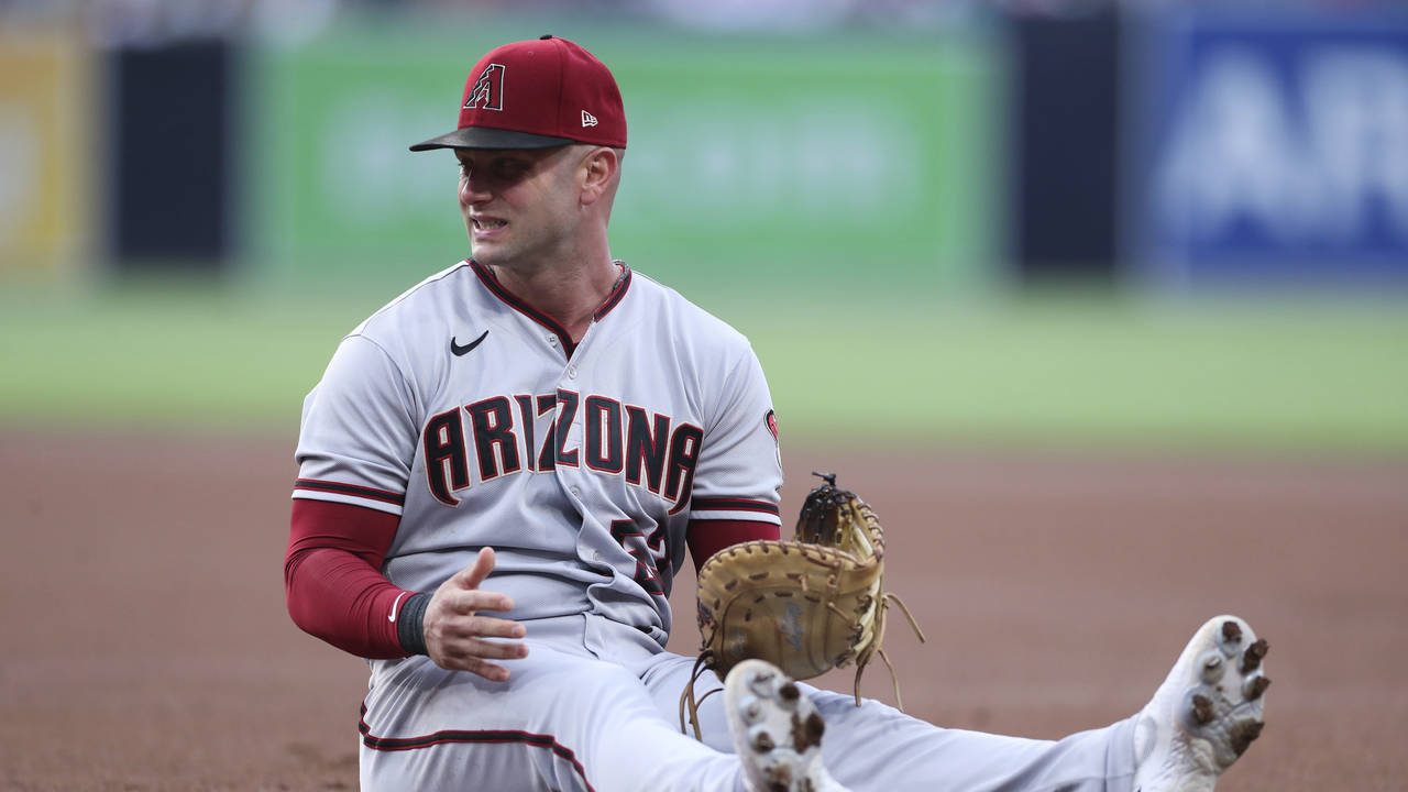 Arizona Diamondbacks first baseman Christian Walker reacts after being pulled off the bag on a thro...