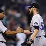 Colorado Rockies relief pitcher Daniel Bard (52) shakes hands with catcher Elias Diaz after the final out of the team's baseball game against the Arizona Diamondbacks on Thursday, July 7, 2022, in Phoenix. The Rockies won 4-3. (AP Photo/Ross D. Franklin)