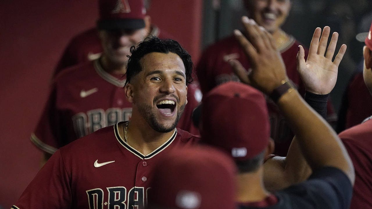 Arizona Diamondbacks' David Peralta gets high fives in the dugout after catching a ball against the...