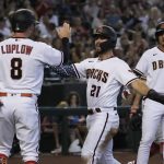 Arizona Diamondbacks' Cooper Hummel (21) and Jordan Luplow (8) celebrate after scoring runs on a ball hit by Buddy Kennedy (not shown) in the first inning during a baseball game against the San Francisco Giants, Monday, July 4, 2022, in Phoenix. (AP Photo/Rick Scuteri)