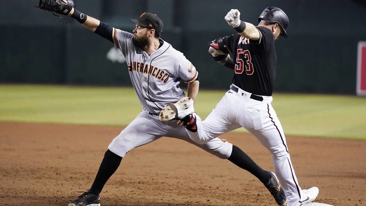 San Francisco Giants first baseman Brandon Belt, left, makes the catch at first base for the out on...