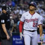 Washington Nationals' Juan Soto frowns after striking out against the Arizona Diamondbacks as umpire Andy Fletcher stands behind the plate during the sixth inning of a baseball game Saturday, July 23, 2022, in Phoenix. (AP Photo/Ross D. Franklin)