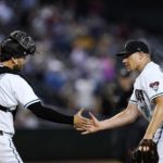 Arizona Diamondbacks relief pitcher Mark Melancon, right, and Diamondbacks catcher Carson Kelly, left, shake hands after the final out in the ninth inning of a baseball game against the San Francisco Giants Tuesday, July 26, 2022, in Phoenix. The Diamondbacks won 7-3. (AP Photo/Ross D. Franklin)