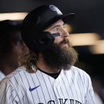 Colorado Rockies' Charlie Blackmon watches a replay of his solo home run off Arizona Diamondbacks relief pitcher Sean Poppen on the big-screen television after returning to the dugout in the eighth inning of a baseball game Friday, July 1, 2022, in Denver. (AP Photo/David Zalubowski)