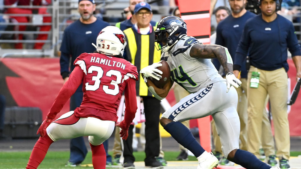 DK Metcalf #14 of the Seattle Seahawks runs the ball after making a catch in front of Antonio Hamil...