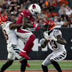 Greg Dortch #83 of the Arizona Cardinals makes a catch while being tackled by Bookie Radley-Hiles #38 and Dax Hill #23 of the Cincinnati Bengals in the second quarter during a preseason game at Paycor Stadium on August 12, 2022 in Cincinnati, Ohio. (Photo by Dylan Buell/Getty Images)