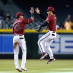 Arizona Diamondbacks center fielder Alek Thomas (5) and shortstop Sergio Alcantara (43) celebrate a win overt the Colorado Rockies after the final out in the ninth inning of a baseball game Sunday, Aug. 7, 2022, in Phoenix. (AP Photo/Ross D. Franklin)
