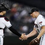 Arizona Diamondbacks relief pitcher Mark Melancon, right, shakes hands with catcher Carson Kelly after the final out of the team's baseball game against the Philadelphia Phillies on Tuesday, Aug. 30, 2022, in Phoenix. The Diamondbacks won 12-3. (AP Photo/Ross D. Franklin)