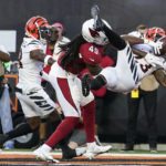 Cincinnati Bengals safety Dax Hill (23) fails to complete an interception in front of Arizona Cardinals tight end Chris Pierce Jr. (49) during the first quarter of an NFL football preseason game in Cincinnati, Friday, Aug. 12, 2022. (AP Photo/Michael Conroy)