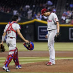 Philadelphia Phillies starting pitcher Aaron Nola (27) gets a visit from catcher Garrett Stubbs, left, during the second inning of the team's baseball game against the Arizona Diamondbacks on Tuesday, Aug. 30, 2022, in Phoenix. (AP Photo/Ross D. Franklin)