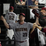Arizona Diamondbacks starting pitcher Merrill Kelly (29) is greeted in the dugout after leaving a baseball game against the Chicago White Sox during the eighth inning Saturday, Aug. 27, 2022, in Chicago. (AP Photo/David Banks)