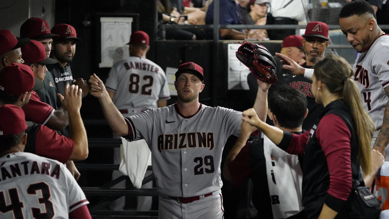 Arizona Diamondbacks starting pitcher Merrill Kelly (29) is greeted in the dugout after leaving a b...