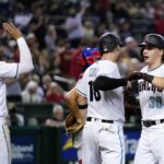 Arizona Diamondbacks' Jake McCarthy (30) celebrates his three-run home run against the Philadelphia Phillies with Carson Kelly, middle, and Josh Rojas (10) during the fourth inning of a baseball game Tuesday, Aug. 30, 2022, in Phoenix. (AP Photo/Ross D. Franklin)